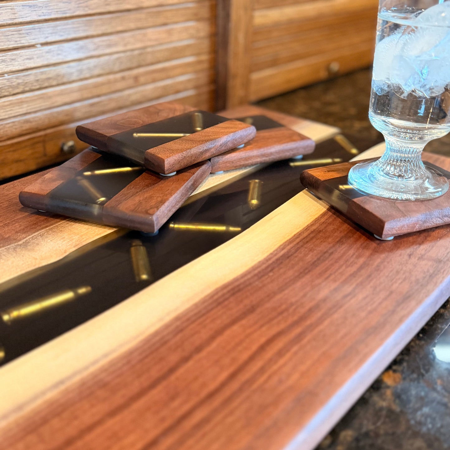 Wooden cutting board with glass of water on a reflective surface