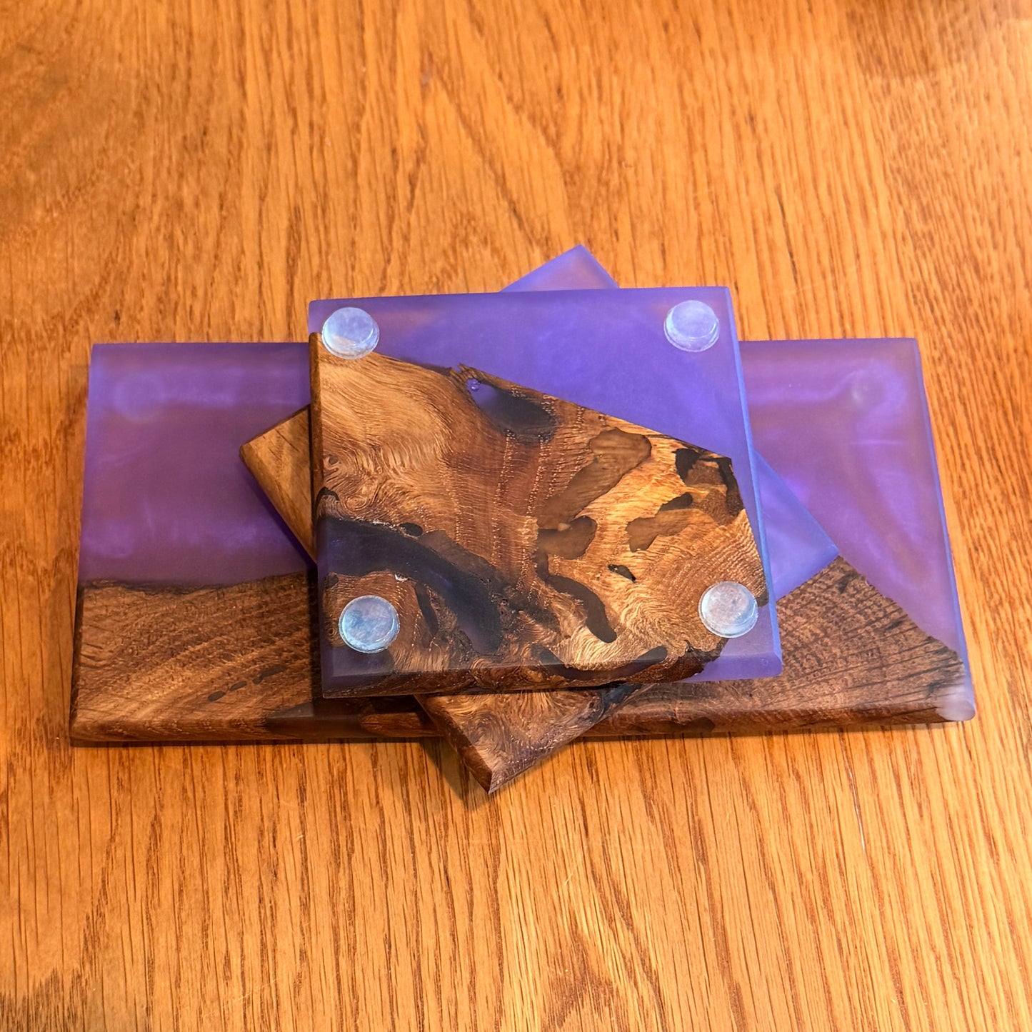 Wooden coasters with purple holders on a wooden surface