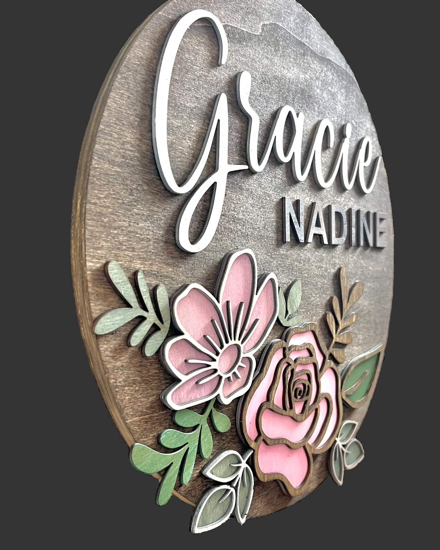 Decorative wall art with floral designs and custom text on a wooden background