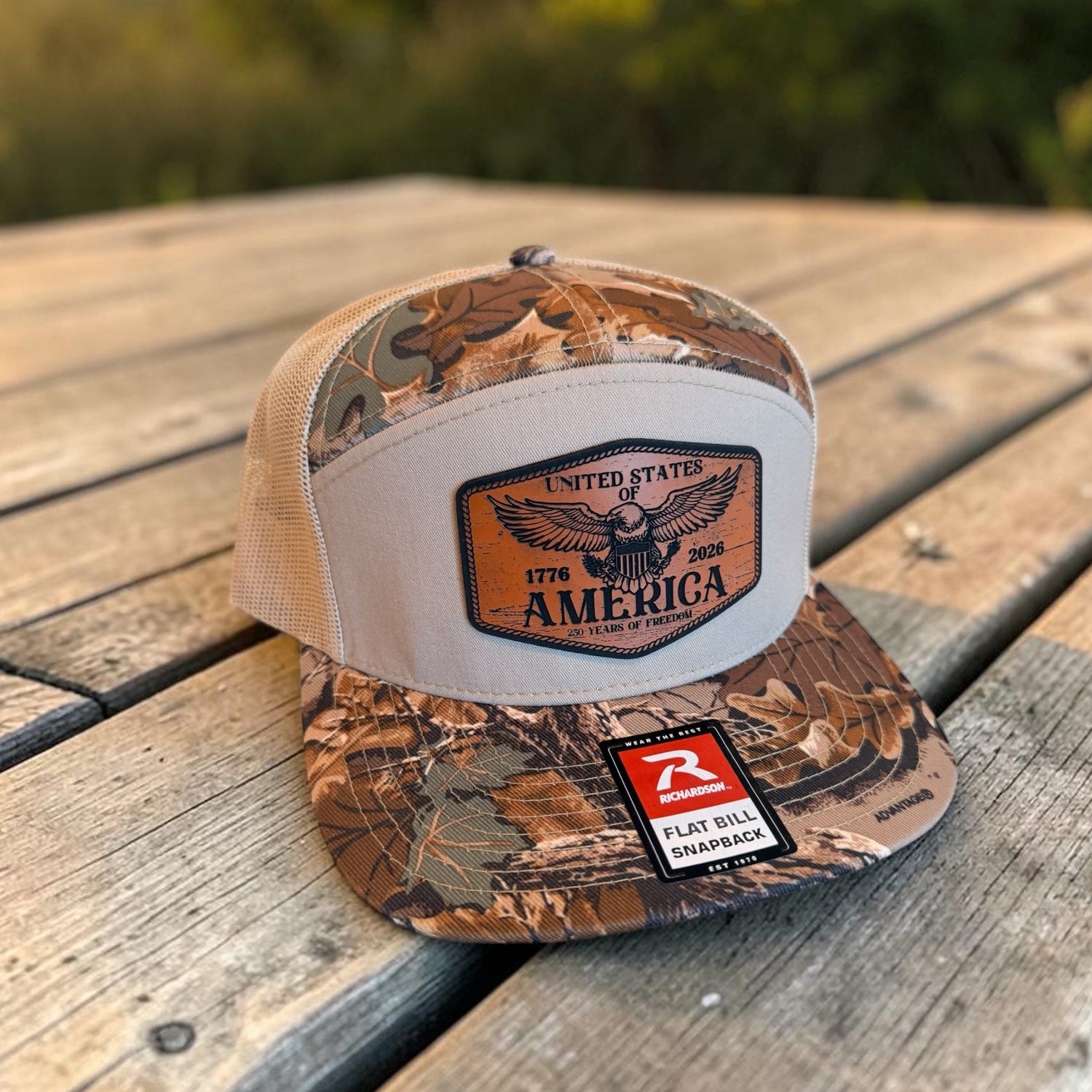 Camouflage trucker hat with 'America' patch on a wooden surface