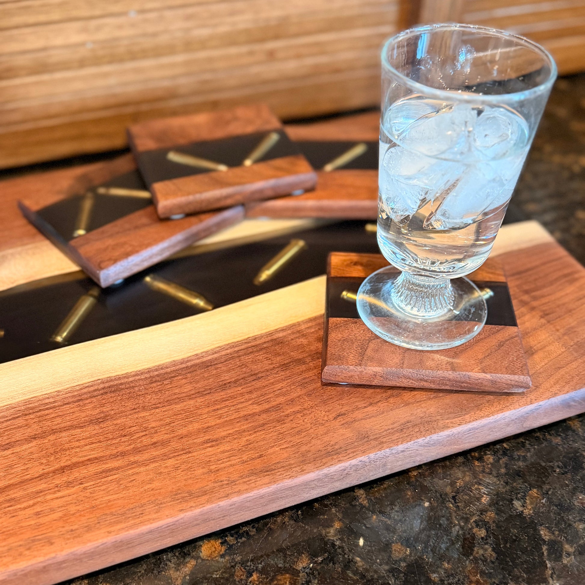 Wooden coasters with a glass of water on a dark surface