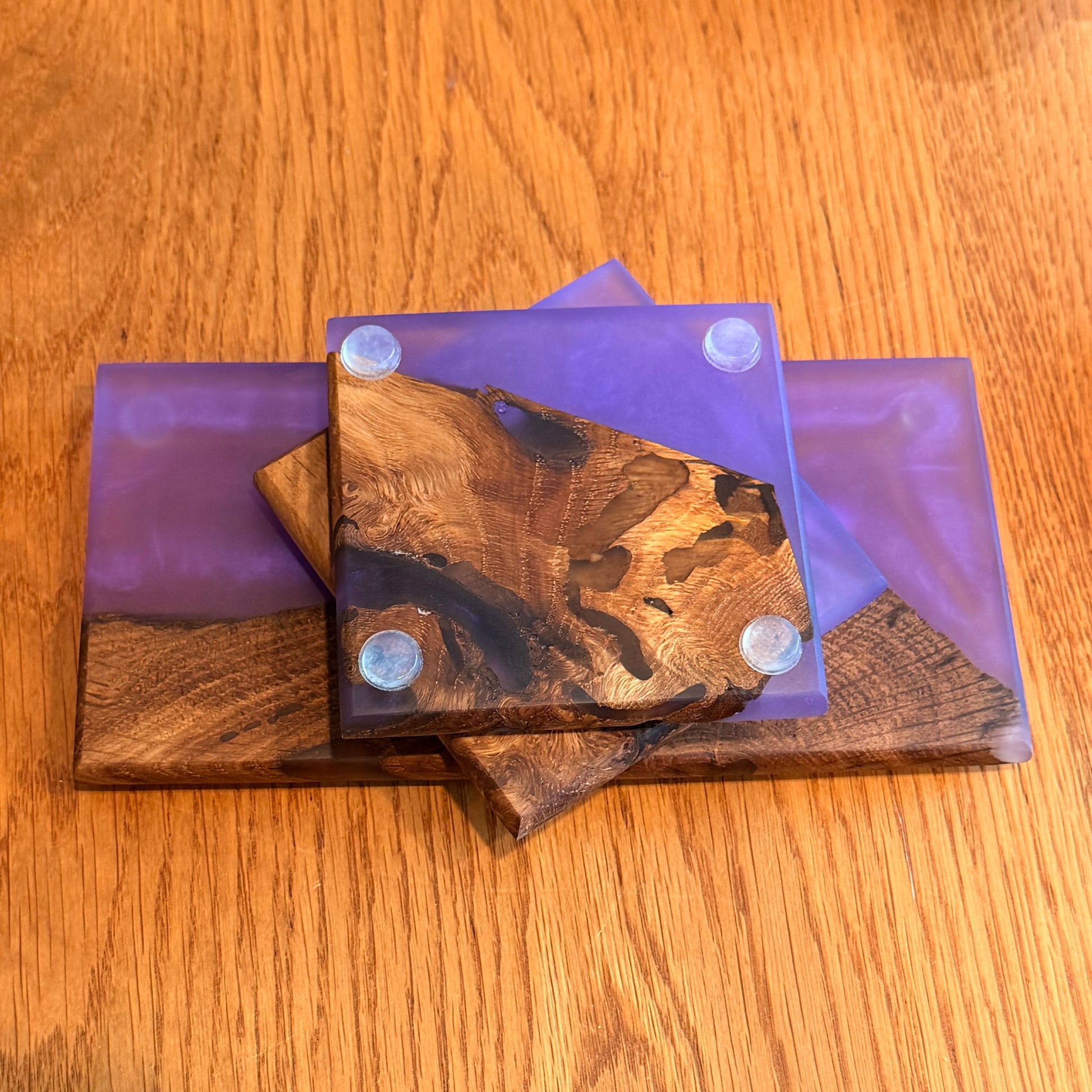 Wooden coasters with purple holders on a wooden surface